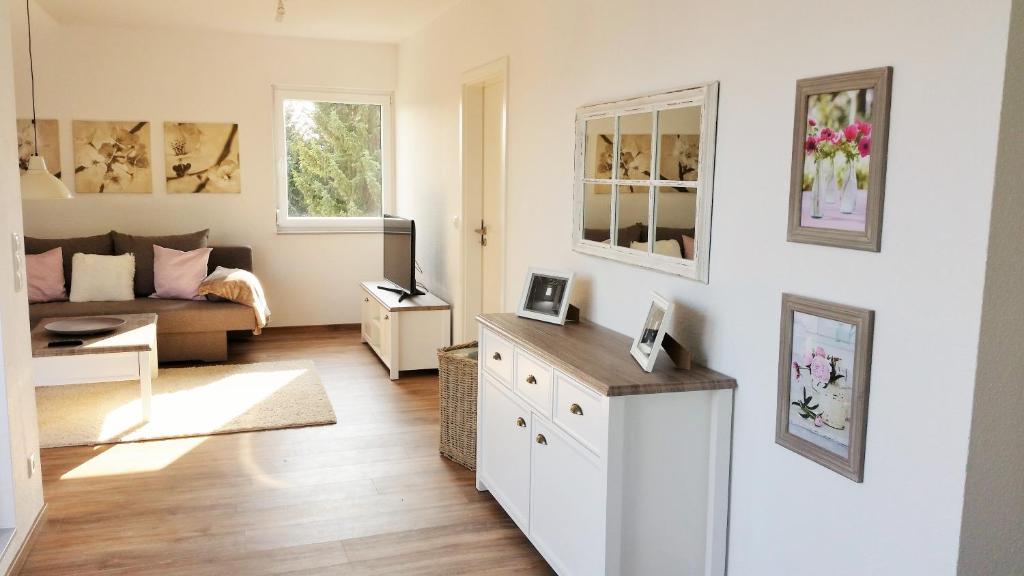 ein weißes Wohnzimmer mit einem Sofa und einem Tisch in der Unterkunft Ferienwohnung Shepherd in Remagen