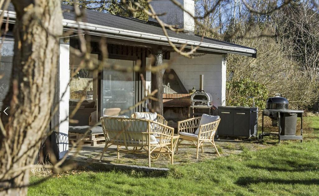 un groupe de chaises assises sur une terrasse dans l'établissement Holiday Home With Garden Near Tisvilde Beach, à Græsted