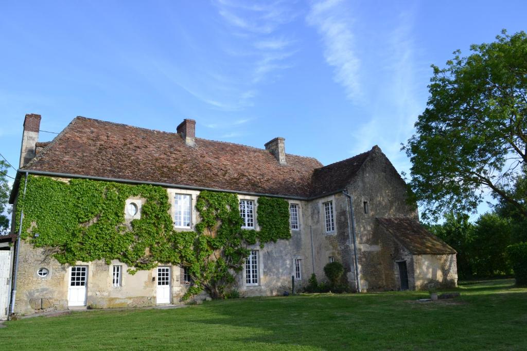 una vieja casa de piedra con hiedra creciendo en ella en La Villa Escuris en Escures-sur-Favières