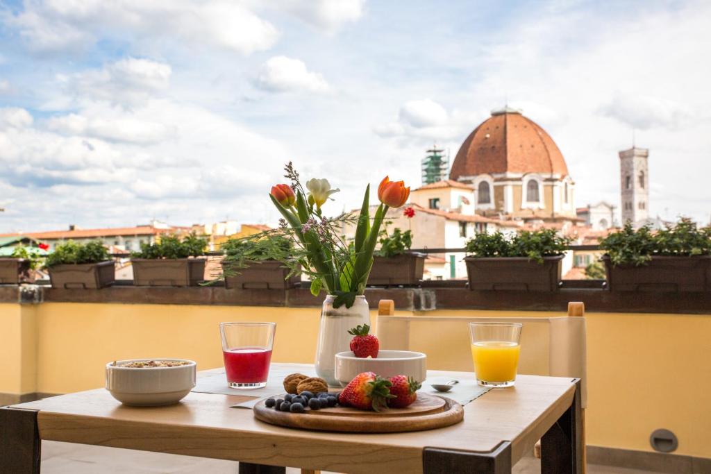 einen Tisch mit Obst und Blumen auf dem Balkon in der Unterkunft Relais Luce Florence in Florenz