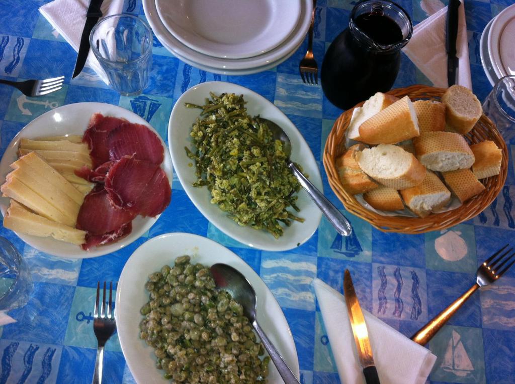 una mesa con platos de comida en un mantel azul en Agriturismo Bingia Bonaria, en Pula