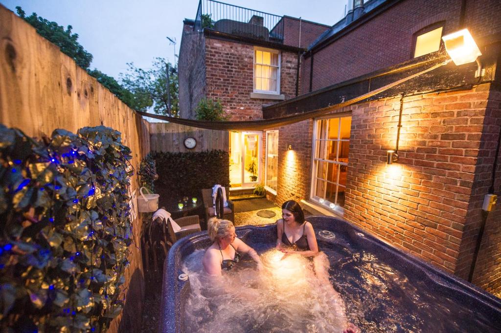 two people in a hot tub in a backyard at Chester Apartments in Chester