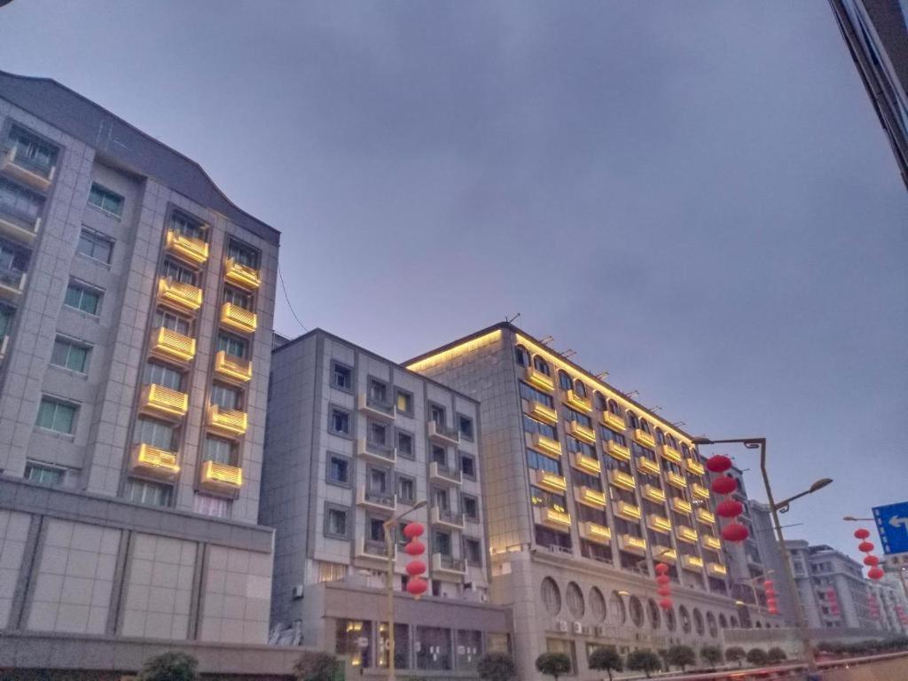 un grand bâtiment éclairé dans une ville dans l'établissement PAI Hotel Nanchong Huaxi Normal University, à Nanchong