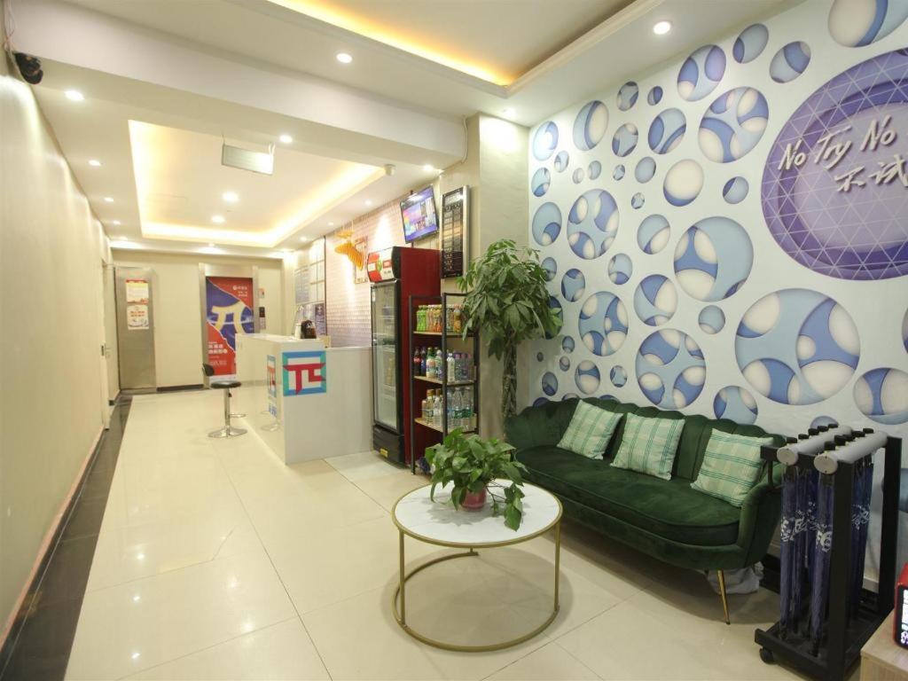 ein Wohnzimmer mit einer grünen Couch und einem Tisch in der Unterkunft Pai Hotel Xuzhou Railway Station in Xuzhou