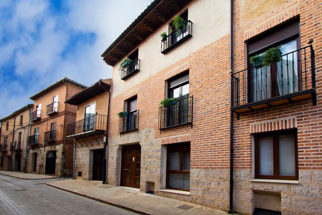 un edificio de ladrillo con ventanas y balcones en una calle en Apartamentos Albero en Toro