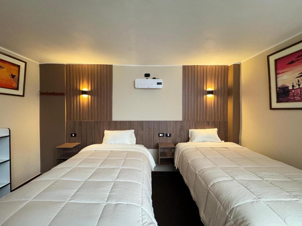 two beds in a hotel room with two beds sidx sidx sidx at Hotel Posada de Belén in Espinar