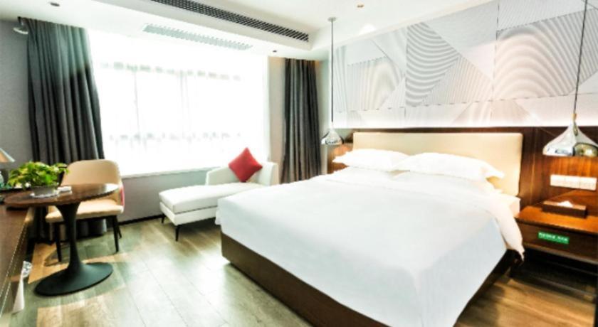 Postel nebo postele na pokoji v ubytování Borrman Hotel Yunfu Xinxing County Bus Station