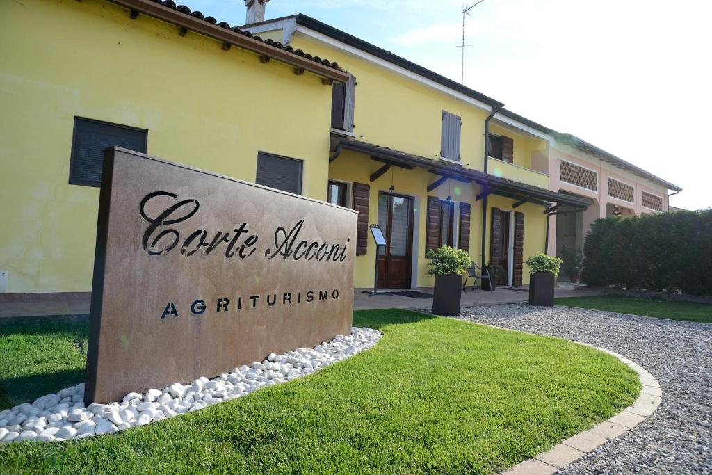 un cartello di fronte a un edificio giallo di Agriturismo Corte Acconi a Mantova