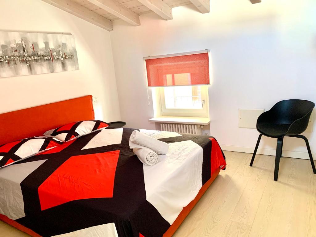 a bedroom with a bed and a chair in it at SteCla's House Garda in Garda