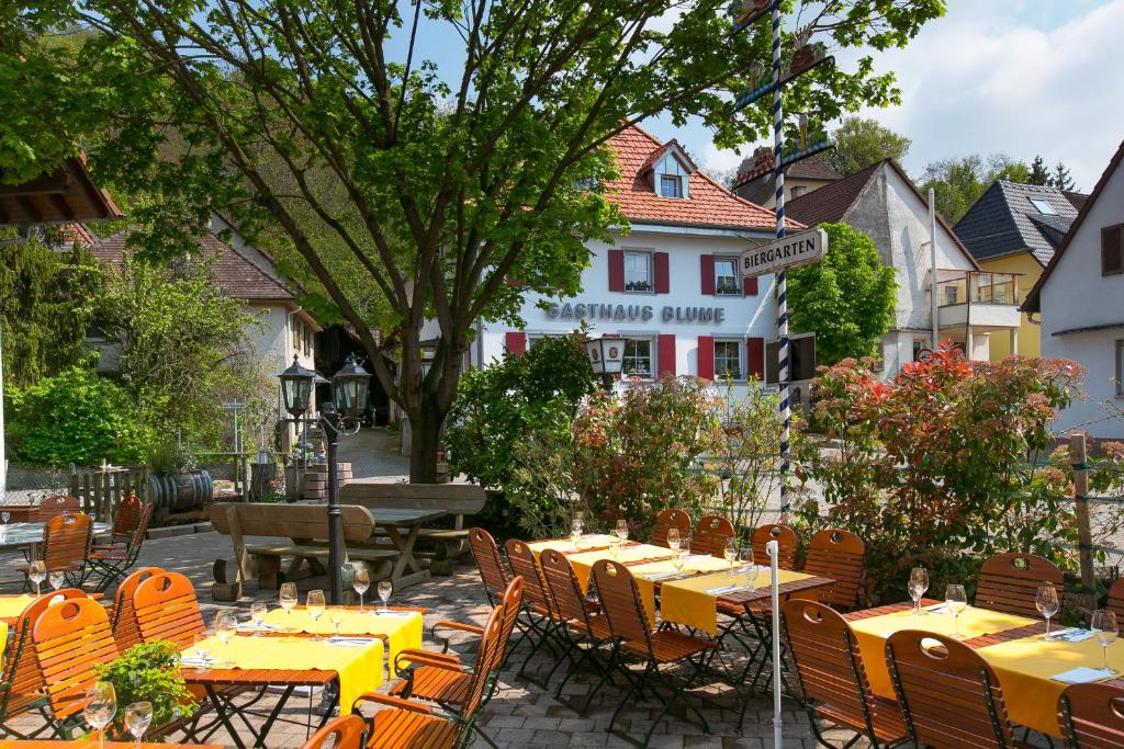 埃夫林根基爾興的住宿－Zur Blume Hotel & Restaurant Efringen-Kirchen bei Basel，户外餐厅设有黄色的桌椅