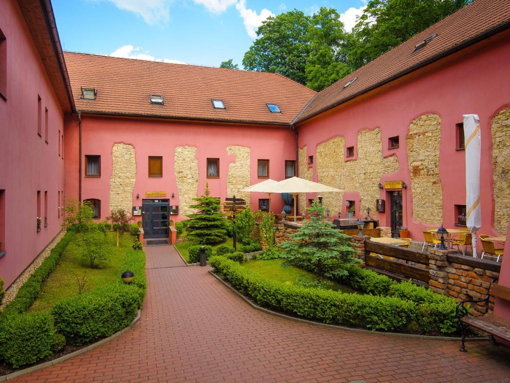 a courtyard of a pink building with a patio at Hotel Stary Pivovar in Prague