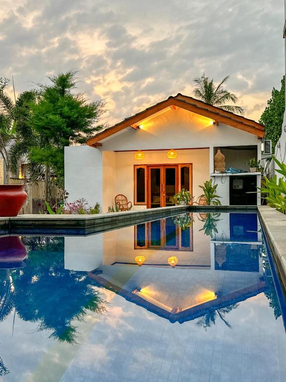 una casa con piscina di fronte a una casa di Hotel Gili Trawangan & Dive a Gili Trawangan