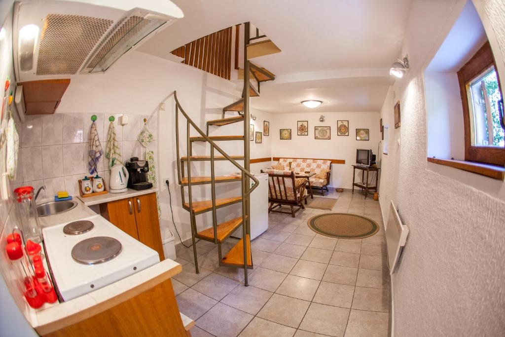 a kitchen with a spiral staircase and a living room at Azur Apartment in Budva