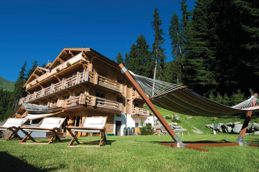 a hammock in front of a log cabin at The Lodge in Verbier