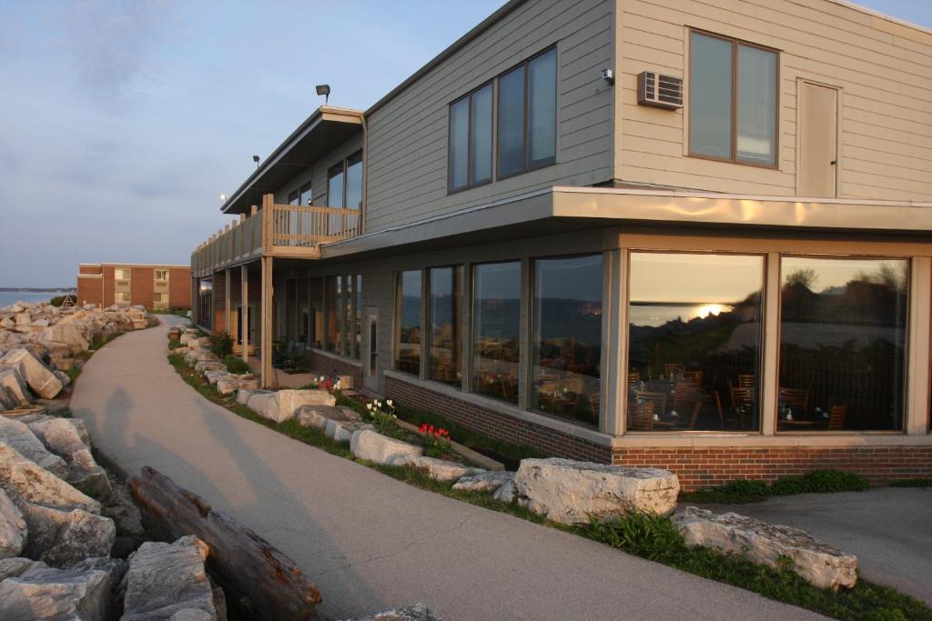 une maison avec de grandes fenêtres en verre et un trottoir dans l'établissement Lighthouse Inn - Two Rivers, à Two Rivers