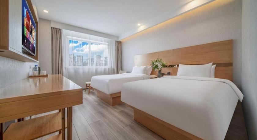 a hotel room with two beds and a desk at GreenTree Inn Haixi Geermu Southern suburbs Express Hotel in Golmud