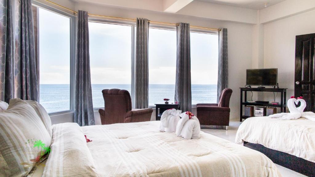two beds in a room with a view of the ocean at Jaynet Oceanview Resort in Boljoon