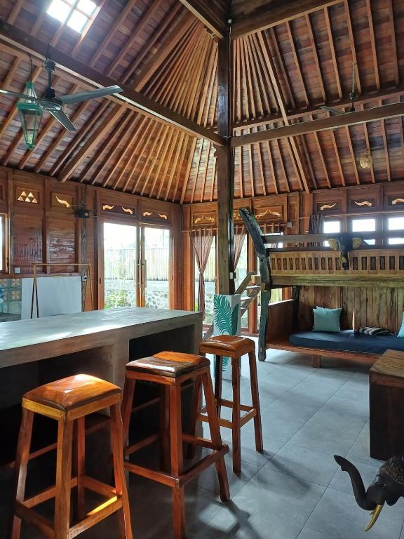 a kitchen with stools and a bar in a hut at Villa Esa Bagus - Volcano view - big pool in Tampaksiring