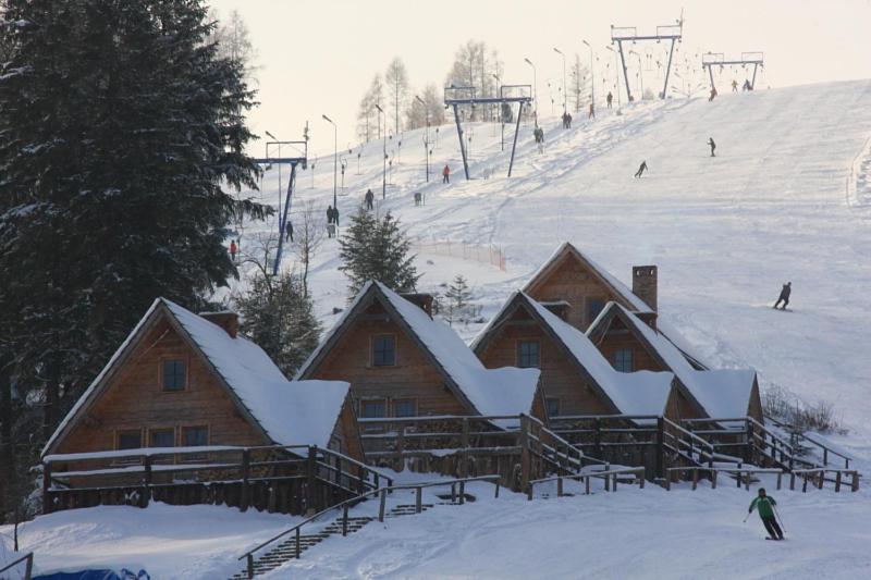 um grupo de casas numa pista de esqui coberta de neve em Domki na Stoku em Ustrzyki Dolne