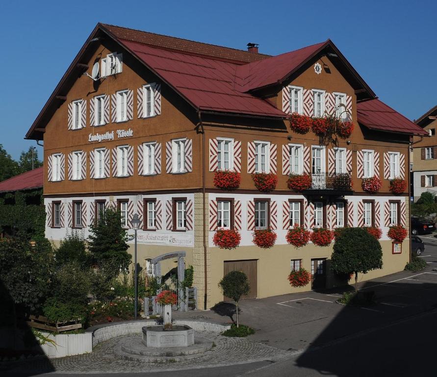 un gran edificio con banderas en sus ventanas en Landgasthof Rössle - Beim Kräuterwirt, en Oberstaufen