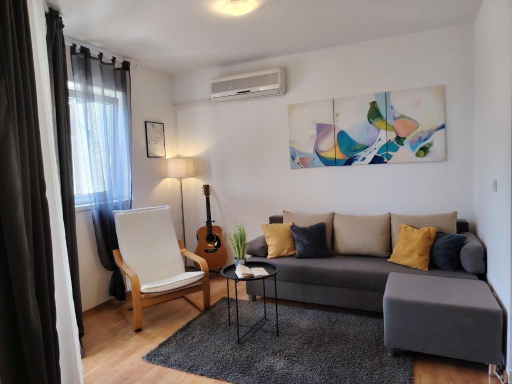 a living room with a couch and a chair at Del Mar Rabac in Rabac