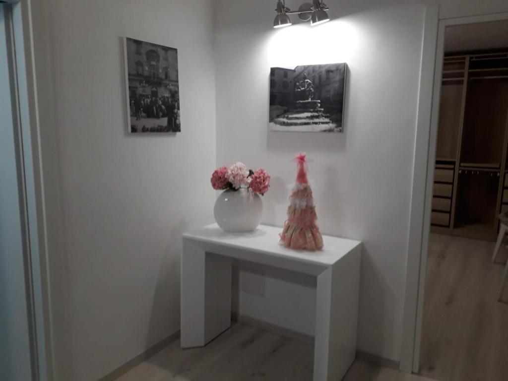 a white table with a vase of flowers on it at alloggio turistico ORTENZIE in Viterbo