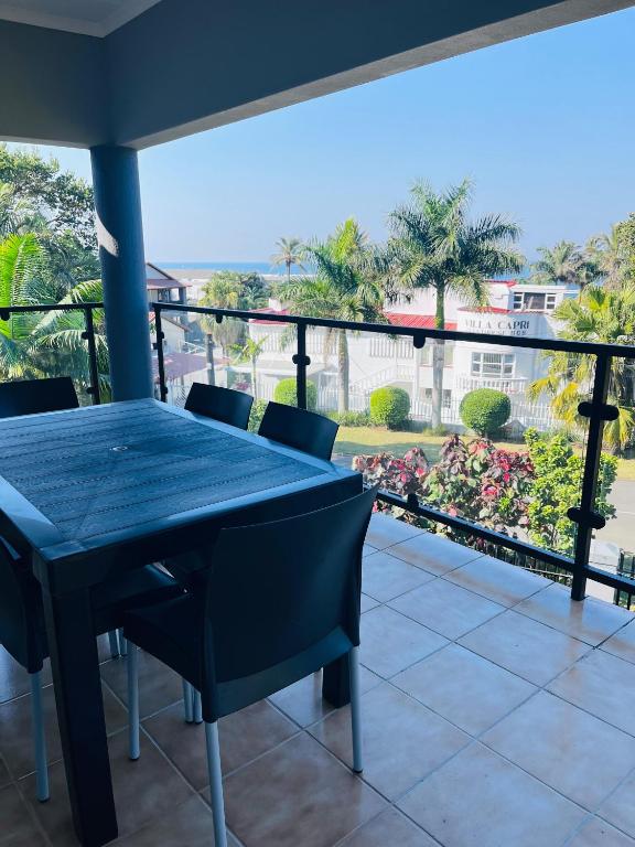 a blue table and chairs on a balcony with a view at Marionguesthouse in Ballito