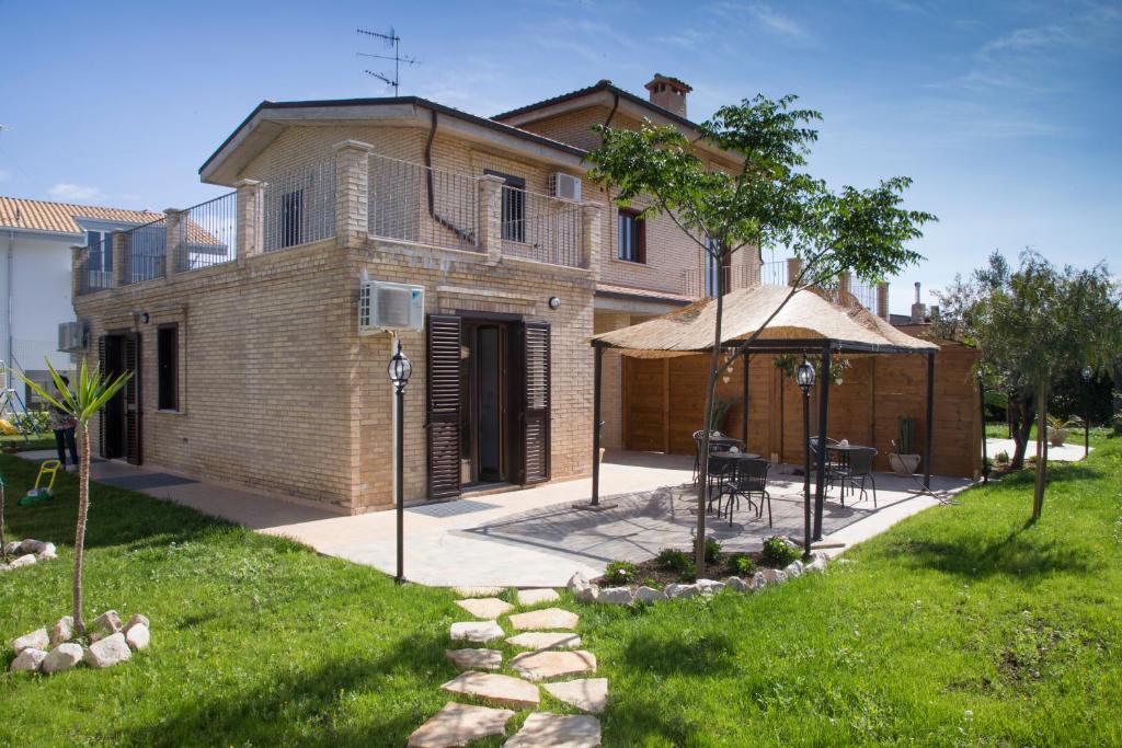 a house with an umbrella and a patio at Villa Saraceni in Vasto