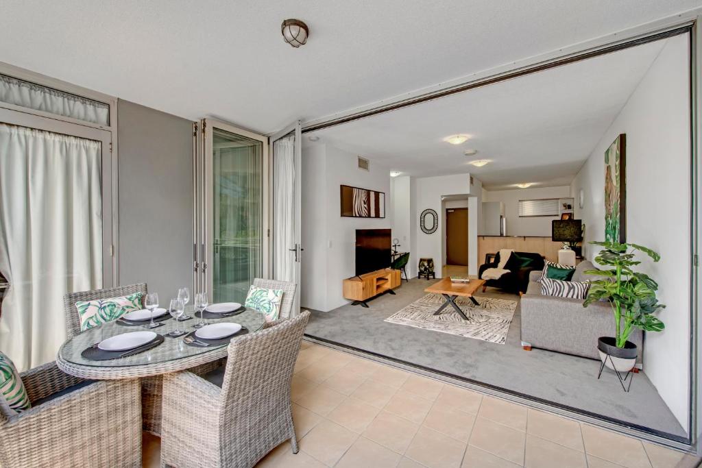 una sala de estar con una mesa y sillas en Wild Luxe Beach Front Escape- 1 min walk Southbank, en Brisbane