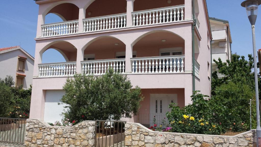 ein großes Haus mit Balkon darüber in der Unterkunft Apartments Pink house in Povljana