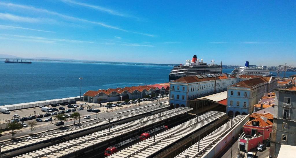 een treinstation met een cruiseschip in het water bij D_Loft River in Lissabon