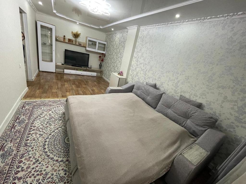 a bedroom with a large bed and a couch at 2-х комнатная квартира in Aktobe