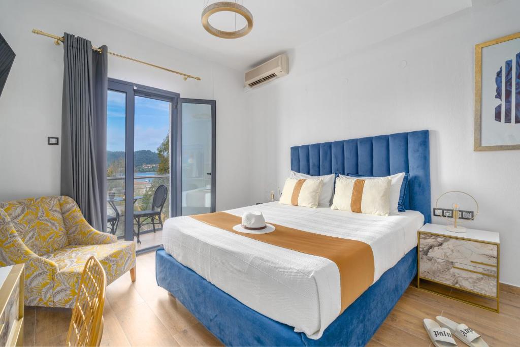 a bedroom with a large bed and a chair at MR P. Boutique Residence in Skiathos
