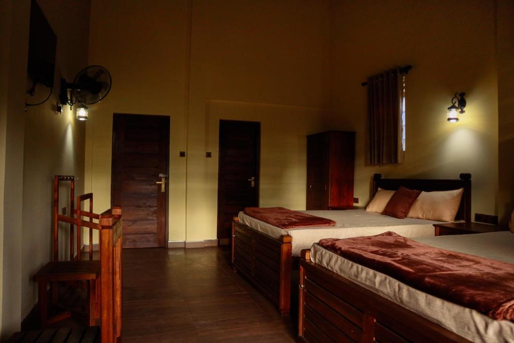 een slaapkamer met 2 bedden en 2 deuren bij The Hidden Heaven in Diyatalawa