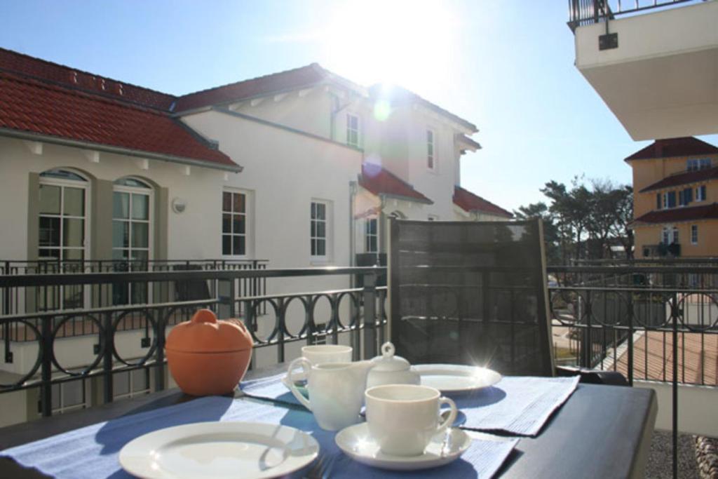 a table with cups and saucers on a balcony at Haus Meeresblick - Ferienwohnung Albatros (Ref. 152813) in Baabe