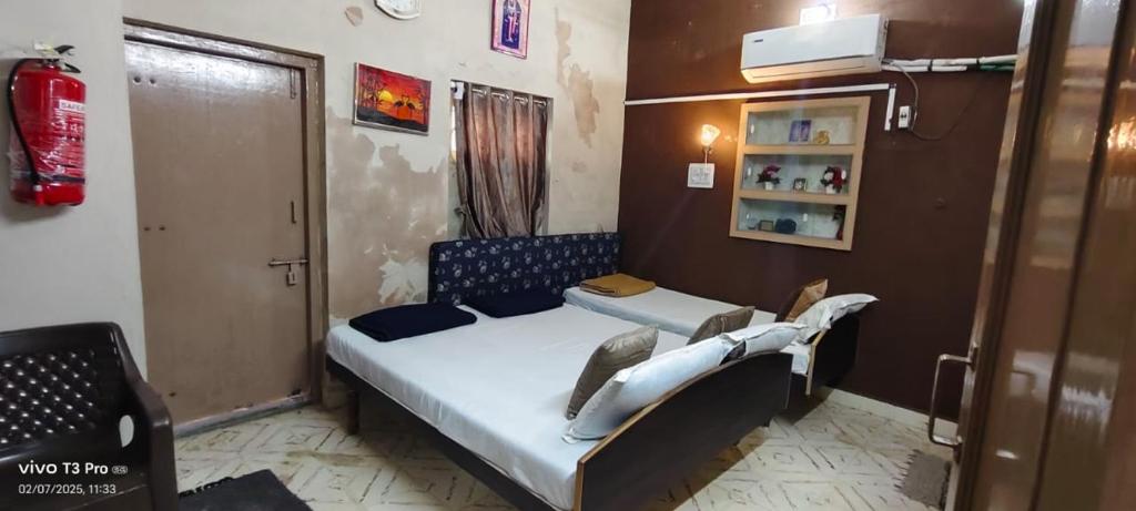 a small bedroom with a bed in a room at Ashirwad bunglow in Dwarka