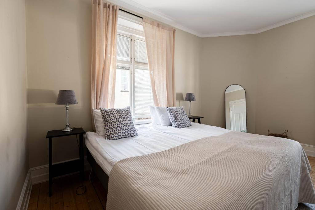 une chambre avec un lit blanc avec une fenêtre dans l'établissement Well-planned 1 bedroom apartment in central Visby, à Visby