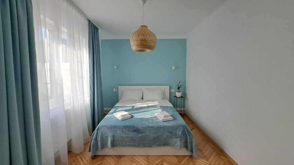 a bedroom with a bed and a blue wall at Cosy House 400 m from Iulius Town in Timişoara