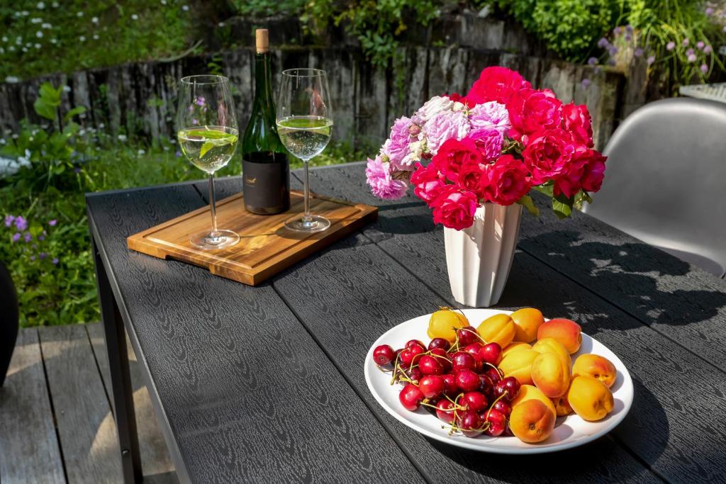 克拉尼斯卡戈拉Villa的桌子上摆着一盘水果、鲜花和酒杯。