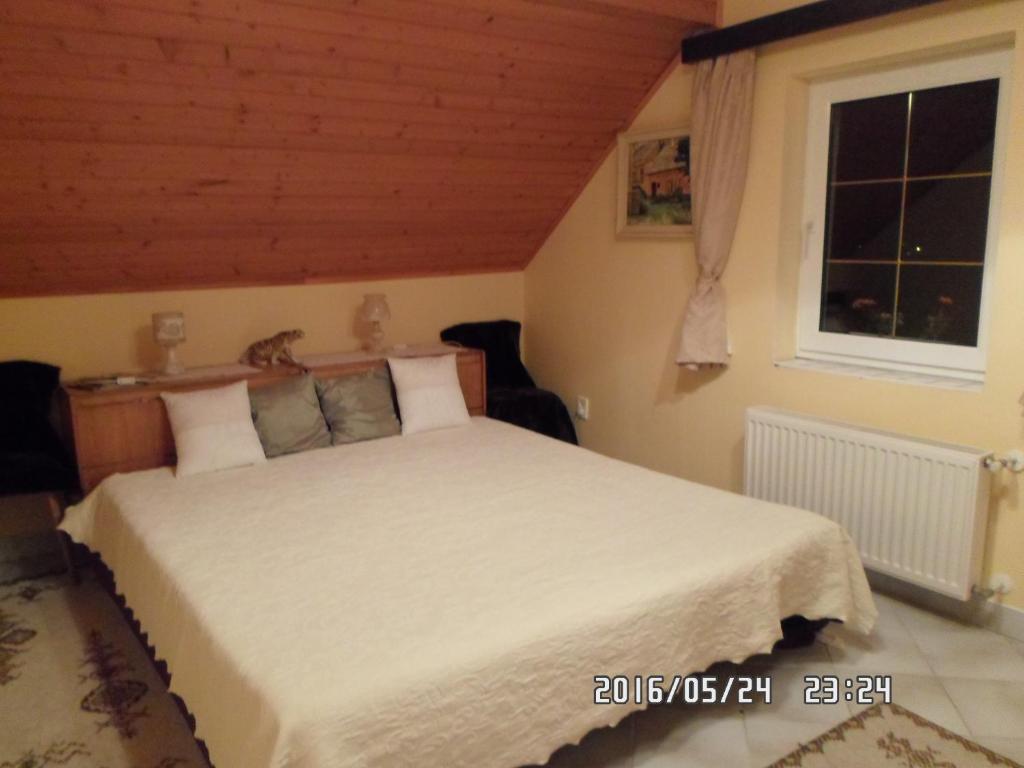 a bedroom with a large white bed with a window at Accommodation close to Budapest in Solymár