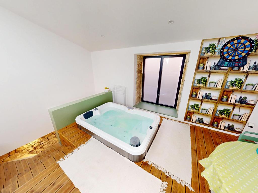 une grande baignoire dans une pièce avec une fenêtre dans l'établissement Maison de maître à Poussan - 6 pers, spa et charme ancien - FR-1-785-21, à Poussan