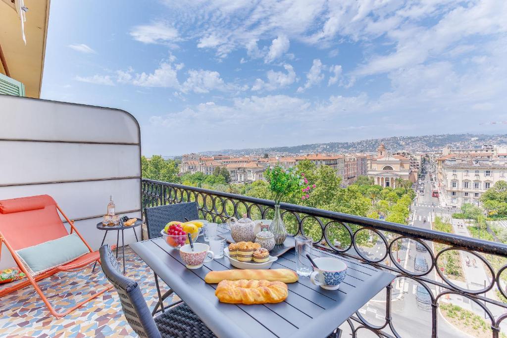 une table avec de la nourriture au sommet d'un balcon dans l'établissement LE PAIROLIERE AP4461 by Riviera Holiday Homes, à Nice