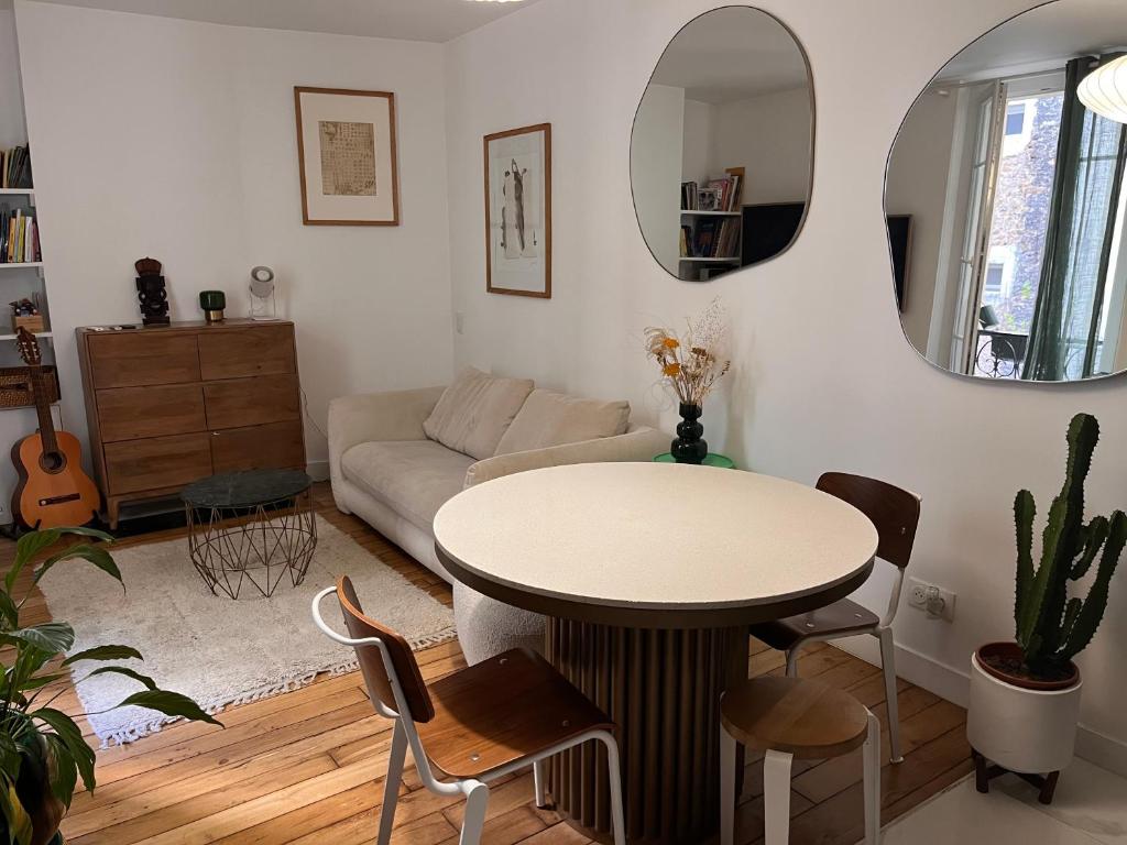 un salon avec une table et un canapé dans l'établissement Appartement neuf design - Montmartre, à Paris