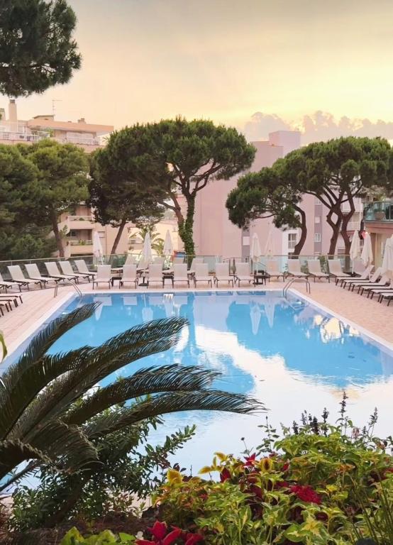 a large swimming pool with chairs and trees at Hotel Las Vegas in Salou
