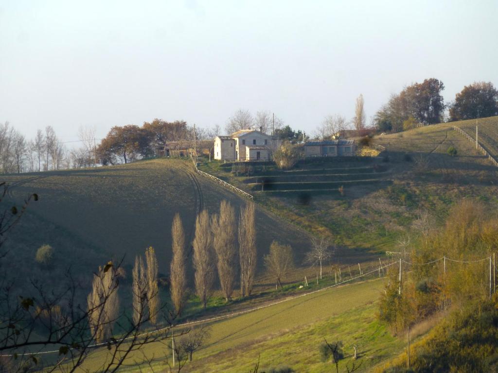 una casa en la cima de una colina con una casa en Locanda San Francesco en Montecarotto