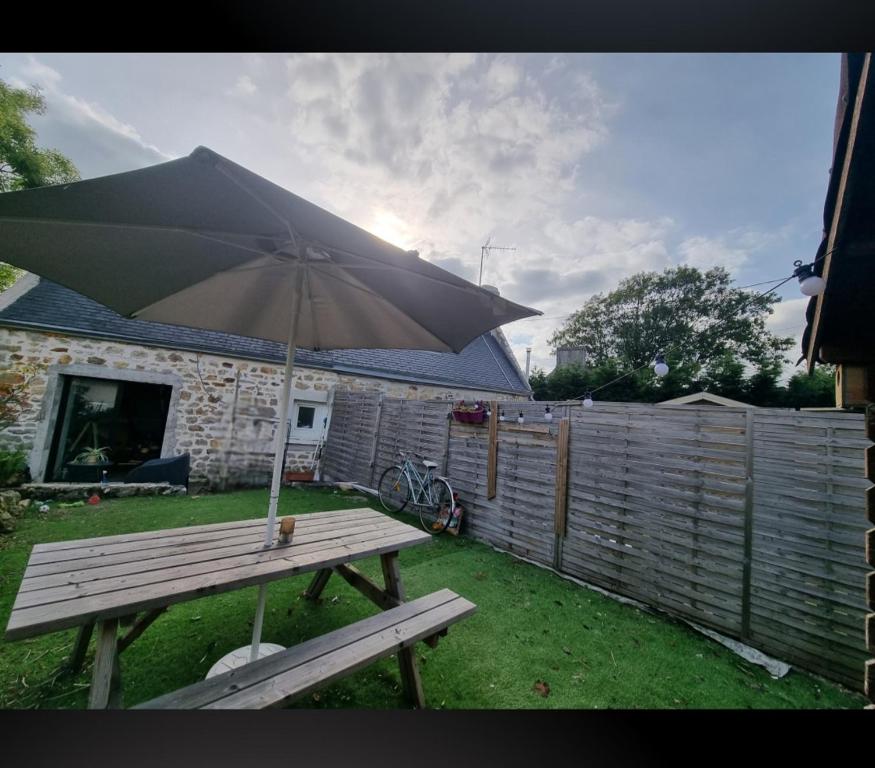 - une table de pique-nique avec un parasol dans la cour dans l'établissement Penty près de la mer, à Combrit