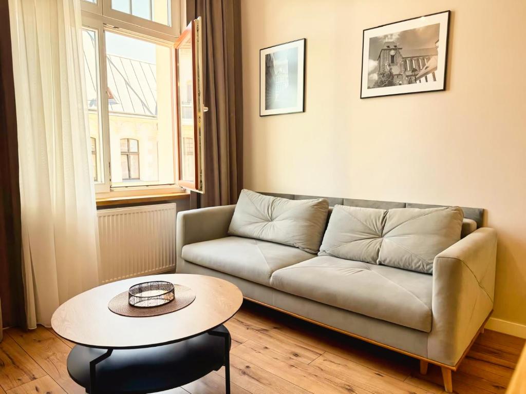 a living room with a couch and a table at Piernikowe by Rentoom in Toruń