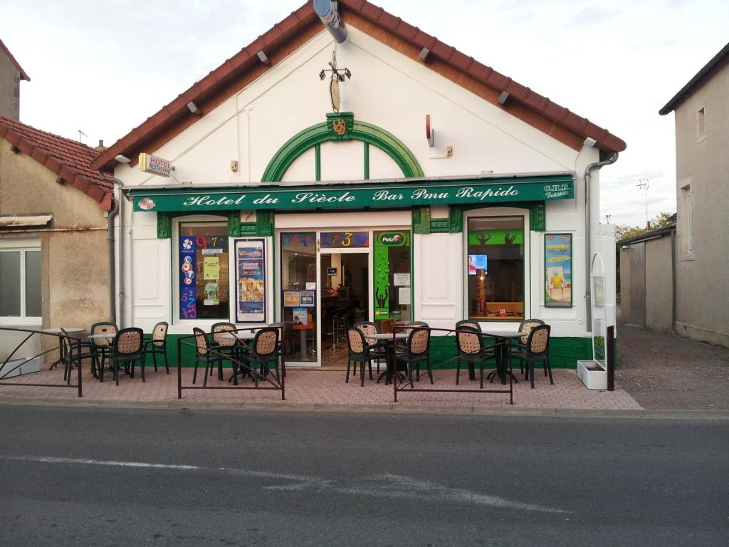 un restaurante con mesas y sillas frente a un edificio en Hotel du siecle, en Cercy-la-Tour