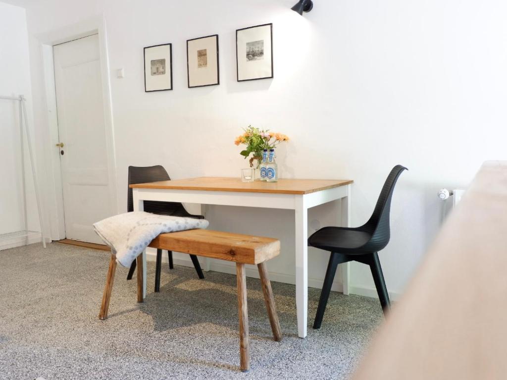 a table and chair with a vase of flowers on it at Appartement Reethus Koppelkiek - kompakt & gemütlich mit Terrasse in Husby