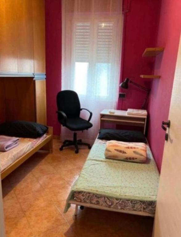 ein Zimmer mit zwei Betten und einem Schreibtisch und einem Stuhl in der Unterkunft Aurora home in Mailand